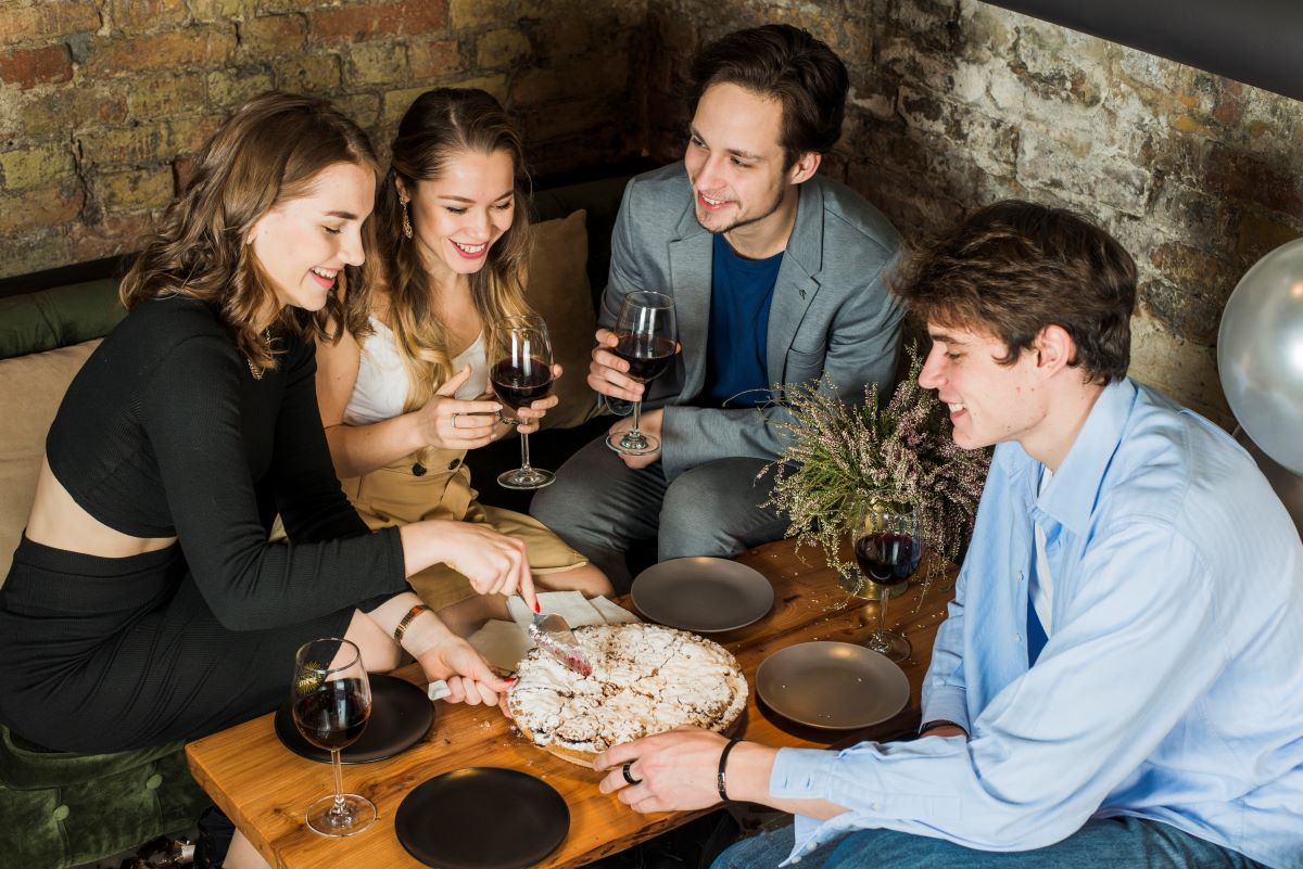 Smiling couples enjoying party with pizza wine