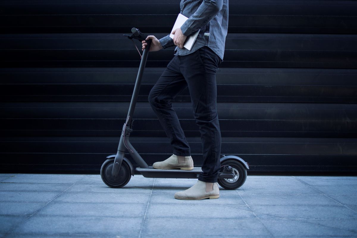 Business person with tablet computer his electric scooter commuting vehicle